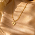 Anti-tarnish gold stainless steel beaded chain necklace with an elongated polished gold heart pendant.
